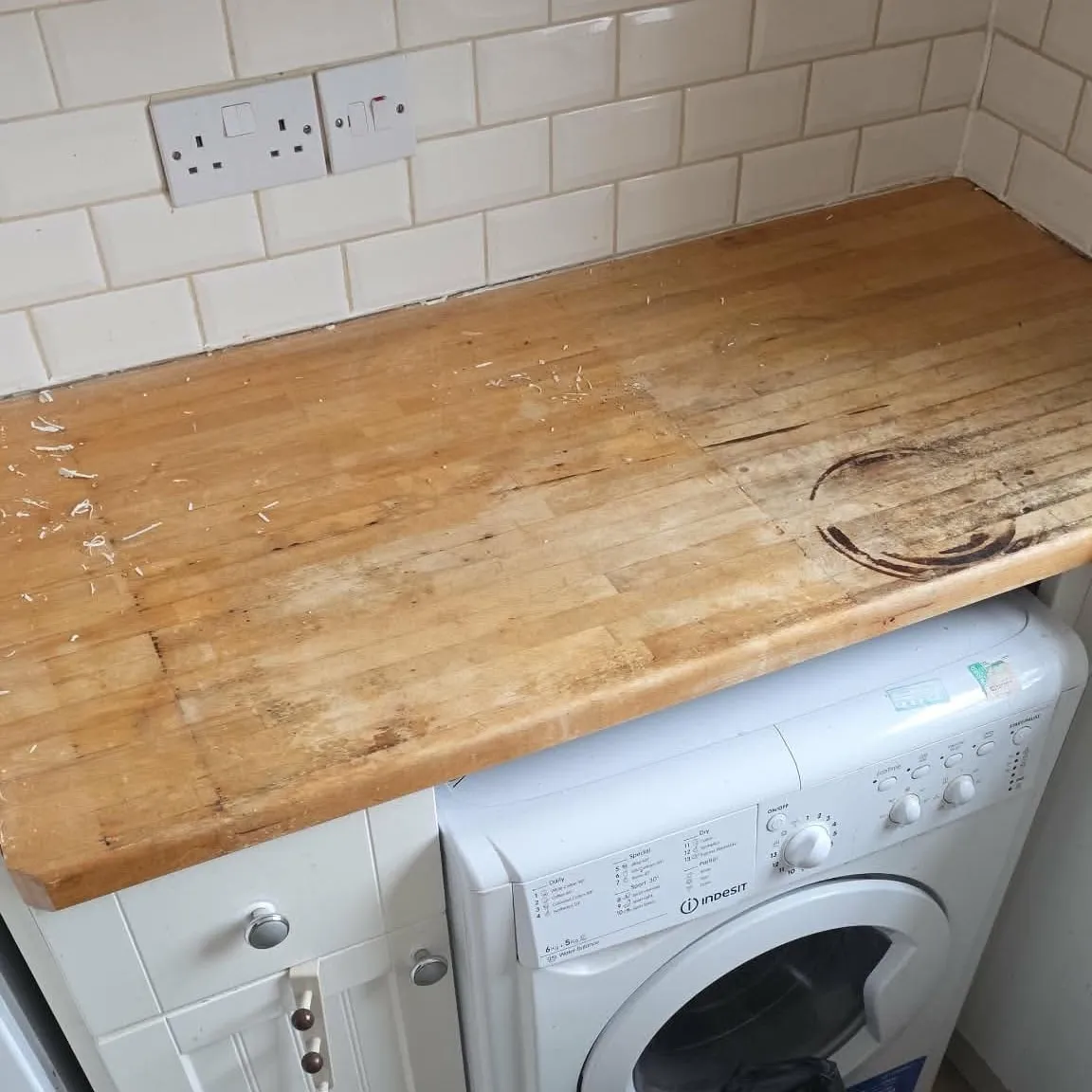Worn wooden kitchen worktop with water stains